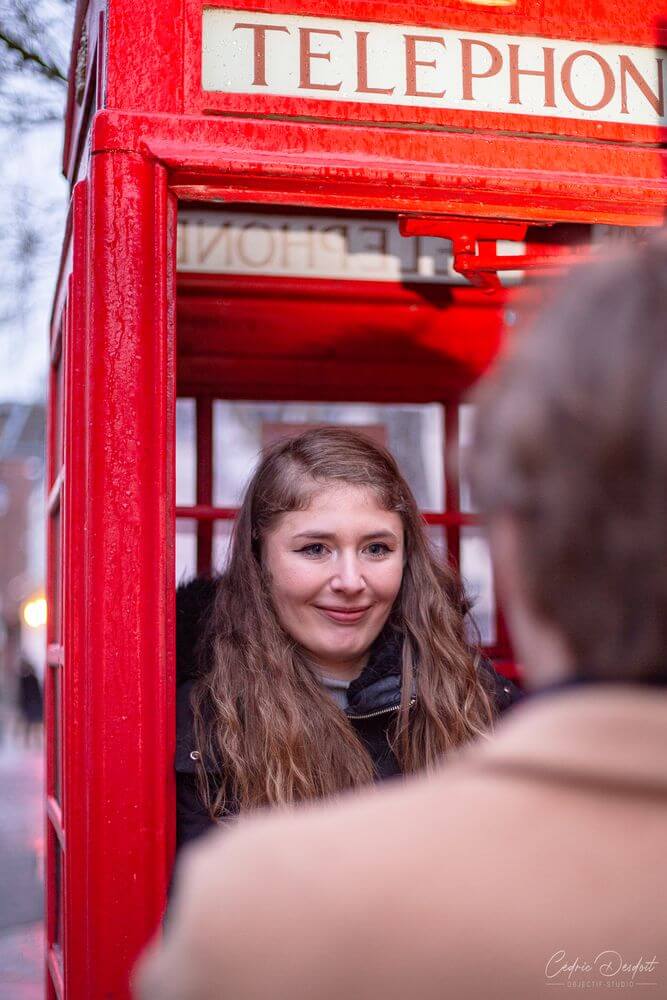 Un couple amoureux devant cabine téléphonique