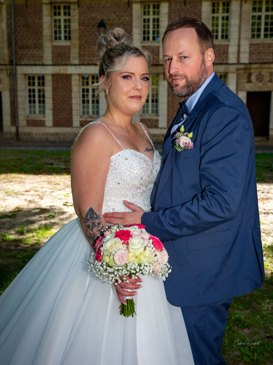 Portrait de couple de mariés devant les façades en brique de la Citadelle d’Arras