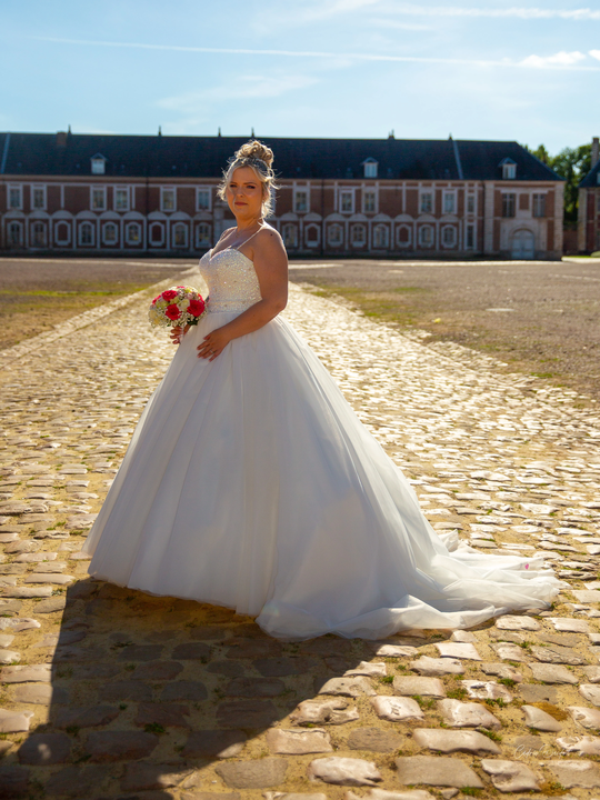 Mariée en robe de princesse posant sur les pavés de la Citadelle d’Arras lors d’un mariage